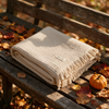 Japanese style summer blanket folded on wooden bench with autumn leaves