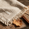 Macro texture detail of waffle knit blanket with autumn leaf