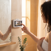 Waterproof phone holder mounted beside a bathroom vanity mirror
